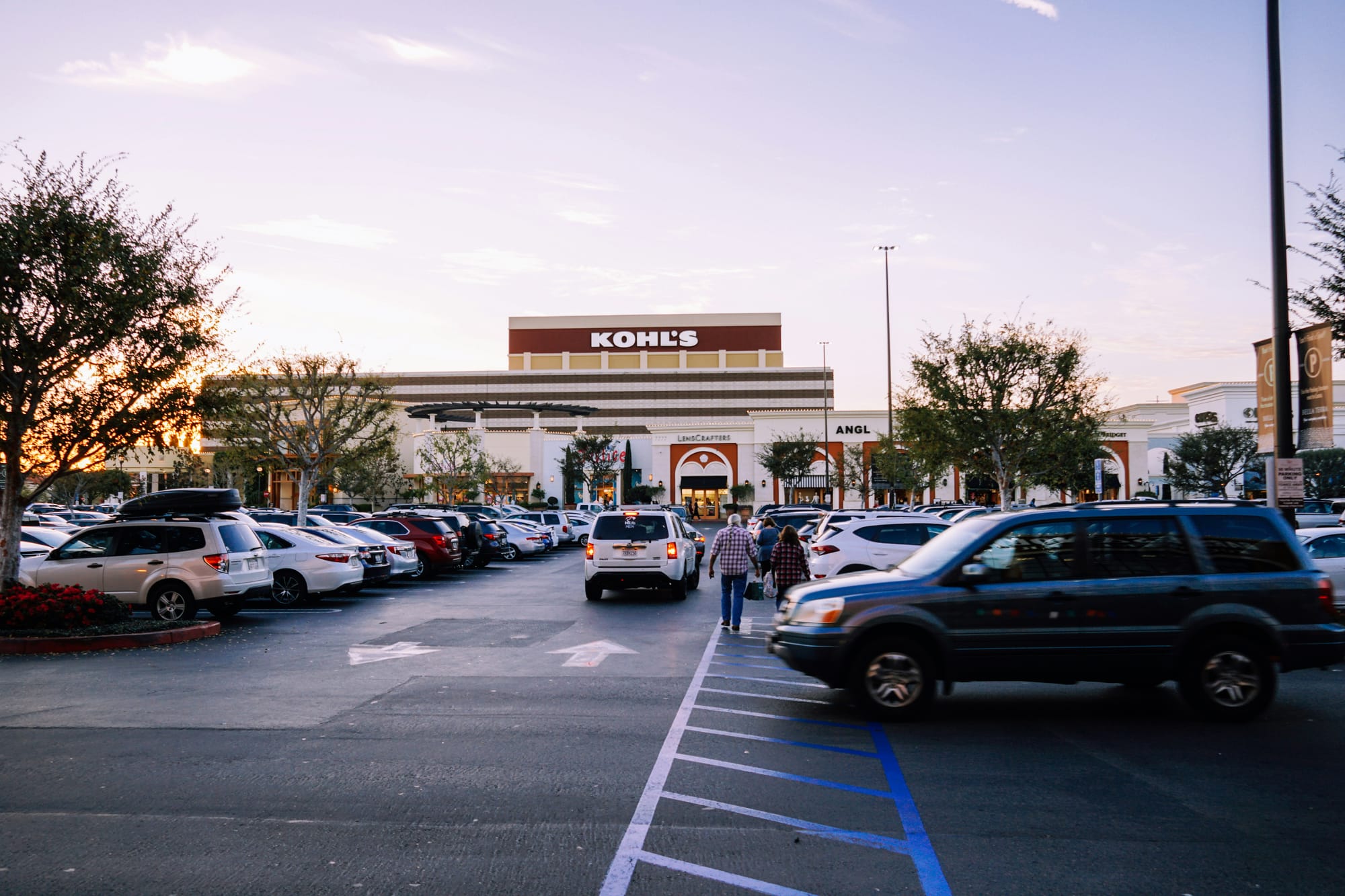 A busy parking lot in front of a shopping center.