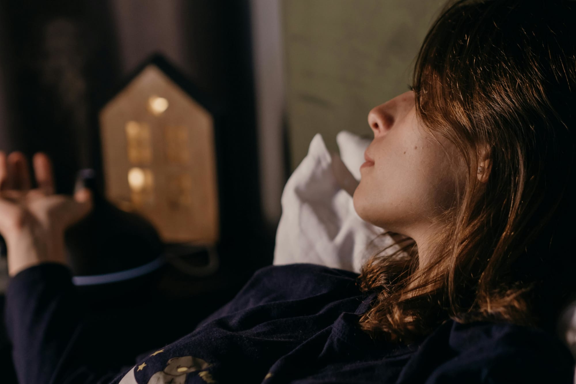 A young woman resting in bed before going to sleep
